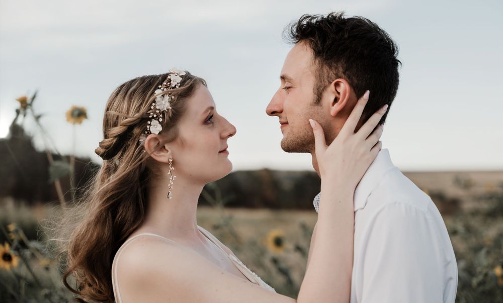 Tender emotional moment between couple during outdoor wedding photoshoot.