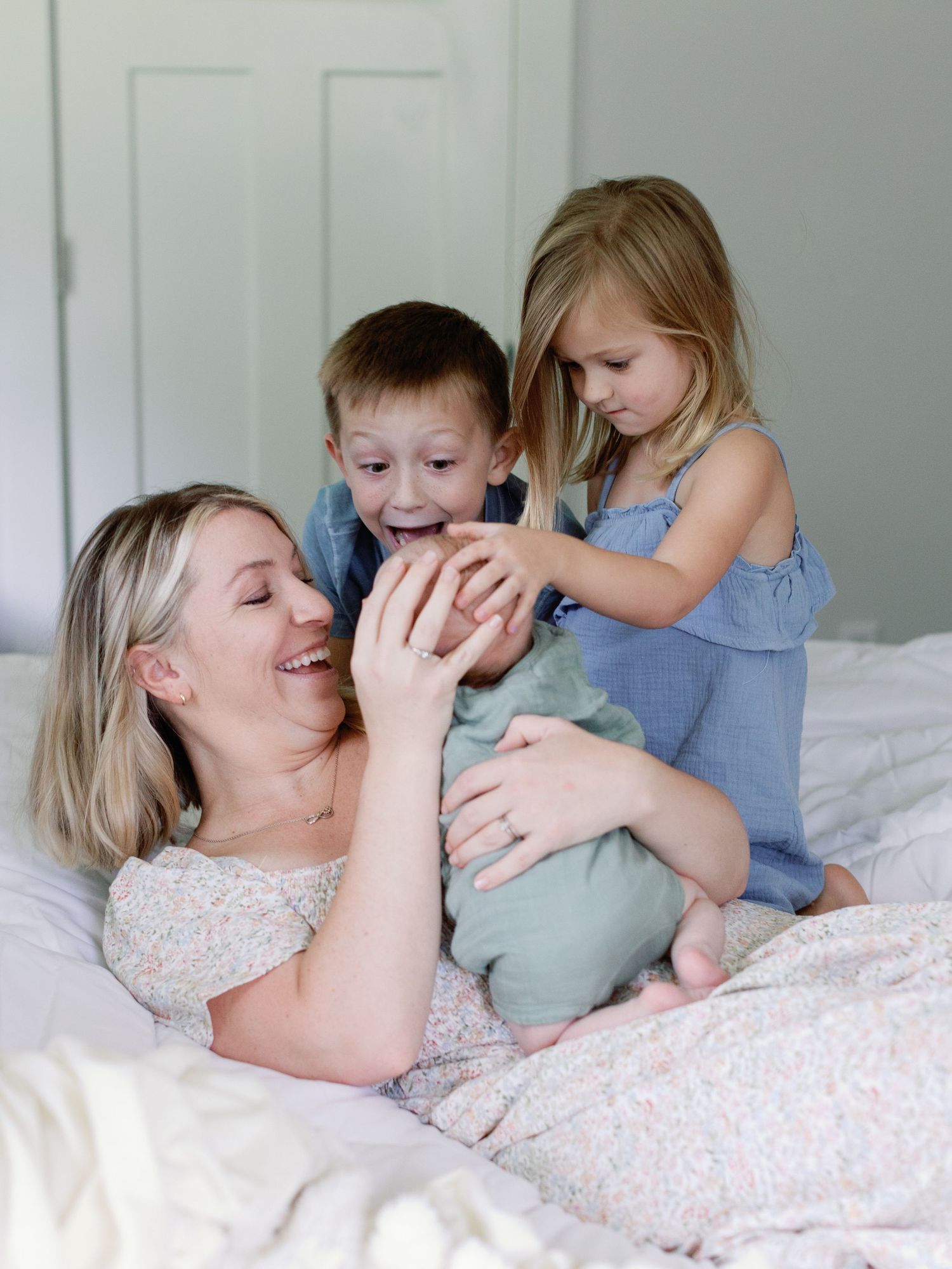 Sweet moment of bonding and laughter on a cozy bed with soft natural lighting.