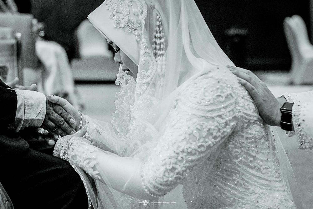 Close-up detail of intricate white lace on traditional Muslim wedding dress.