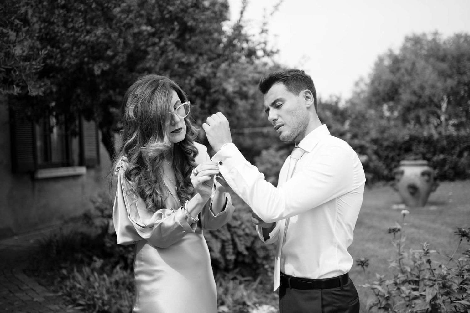 A romantic black and white portrait in a garden setting with elegant formal wear.