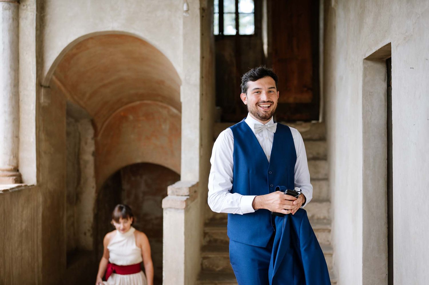 A formal occasion in an elegant archway corridor with contrasting blue and white attire.