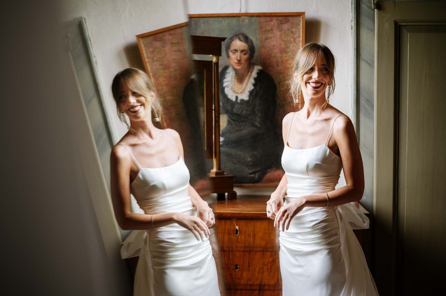 Artistic reflection of bride in vintage mirror with antique furniture setting.
