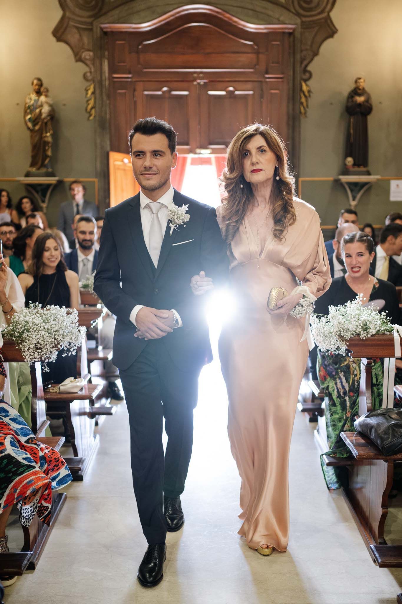 A couple walks down the aisle in a church decorated with baby's breath flowers.