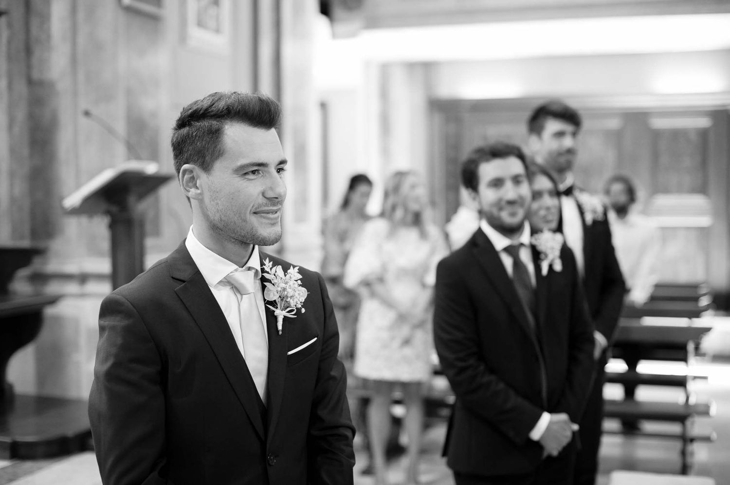 Wedding party members share joyful moments inside an elegant church venue.