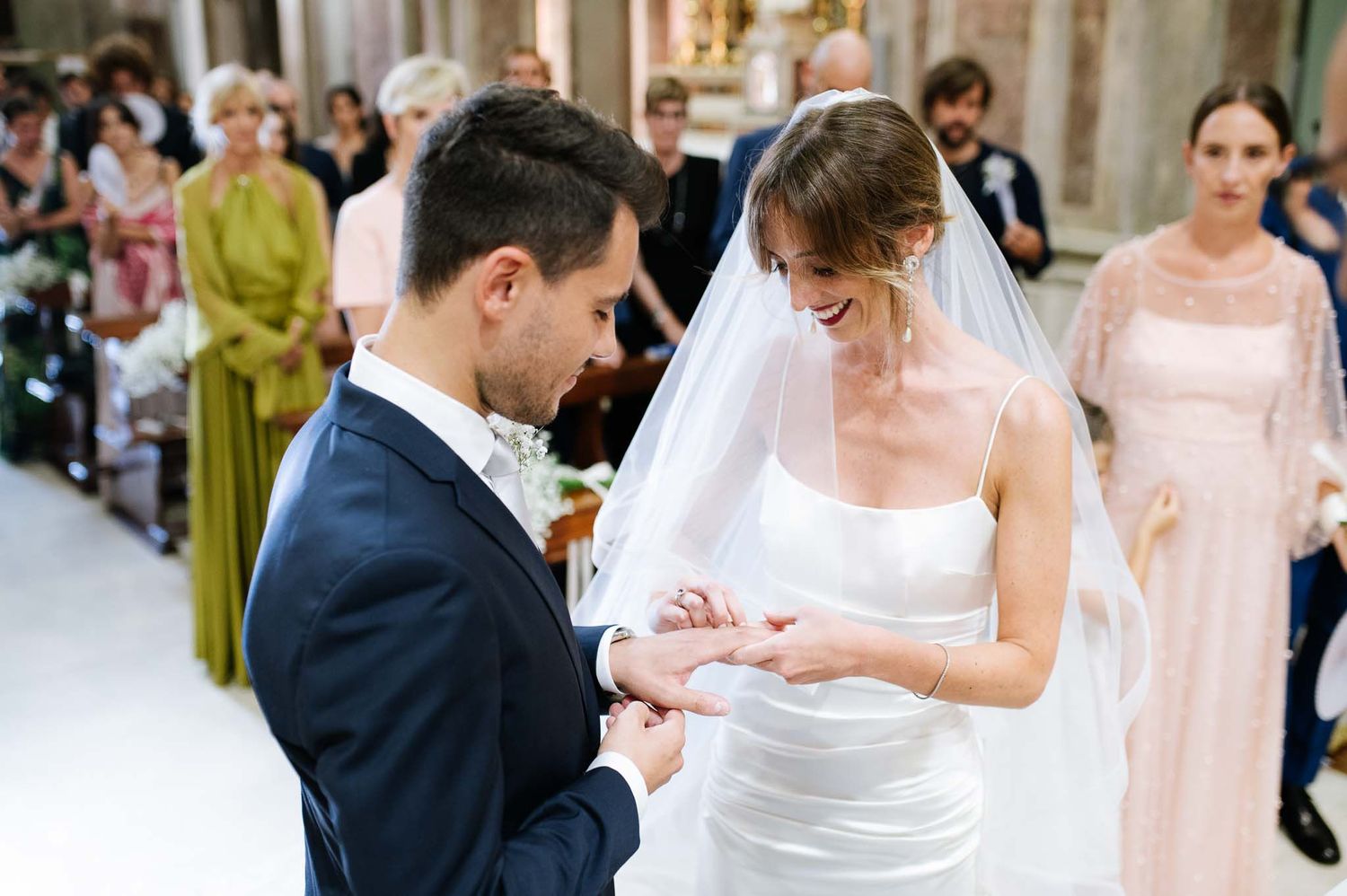 Couple exchanges rings during traditional church wedding ceremony.