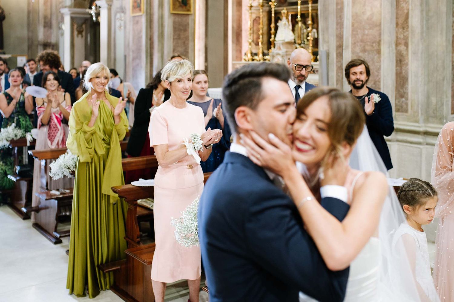 Emotional wedding ceremony moment captured in a church with guests watching.
