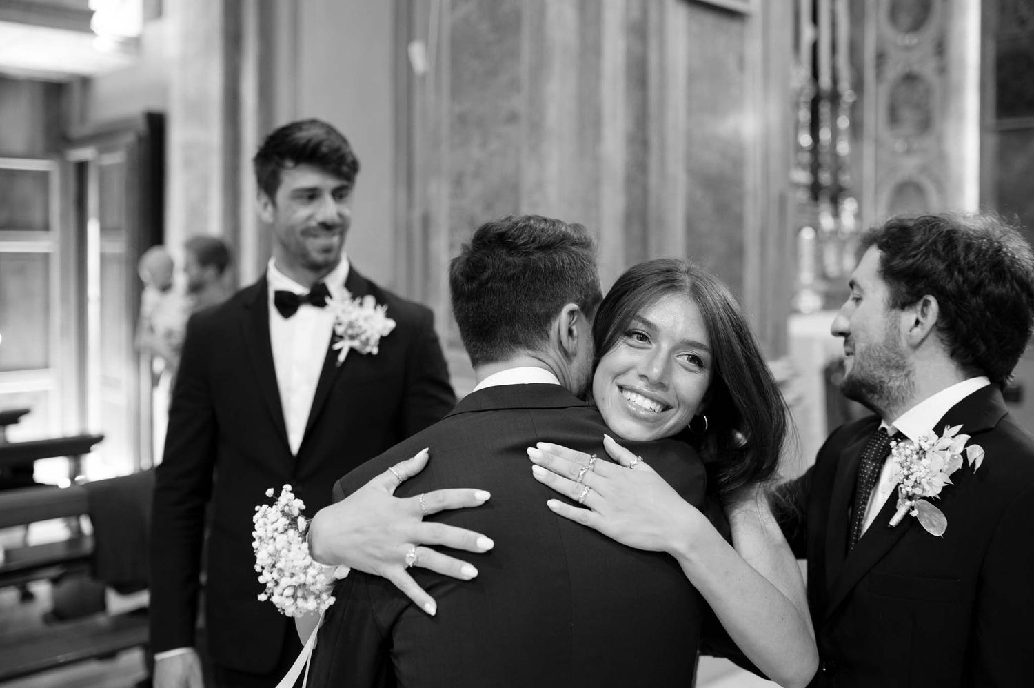 Black and white photo of an emotional embrace during a wedding ceremony.