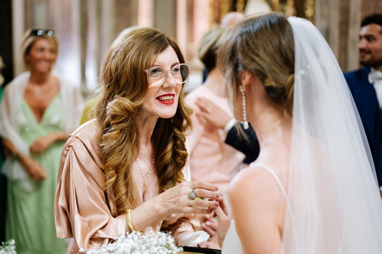 An emotional congratulatory moment between wedding guests captured during the ceremony.