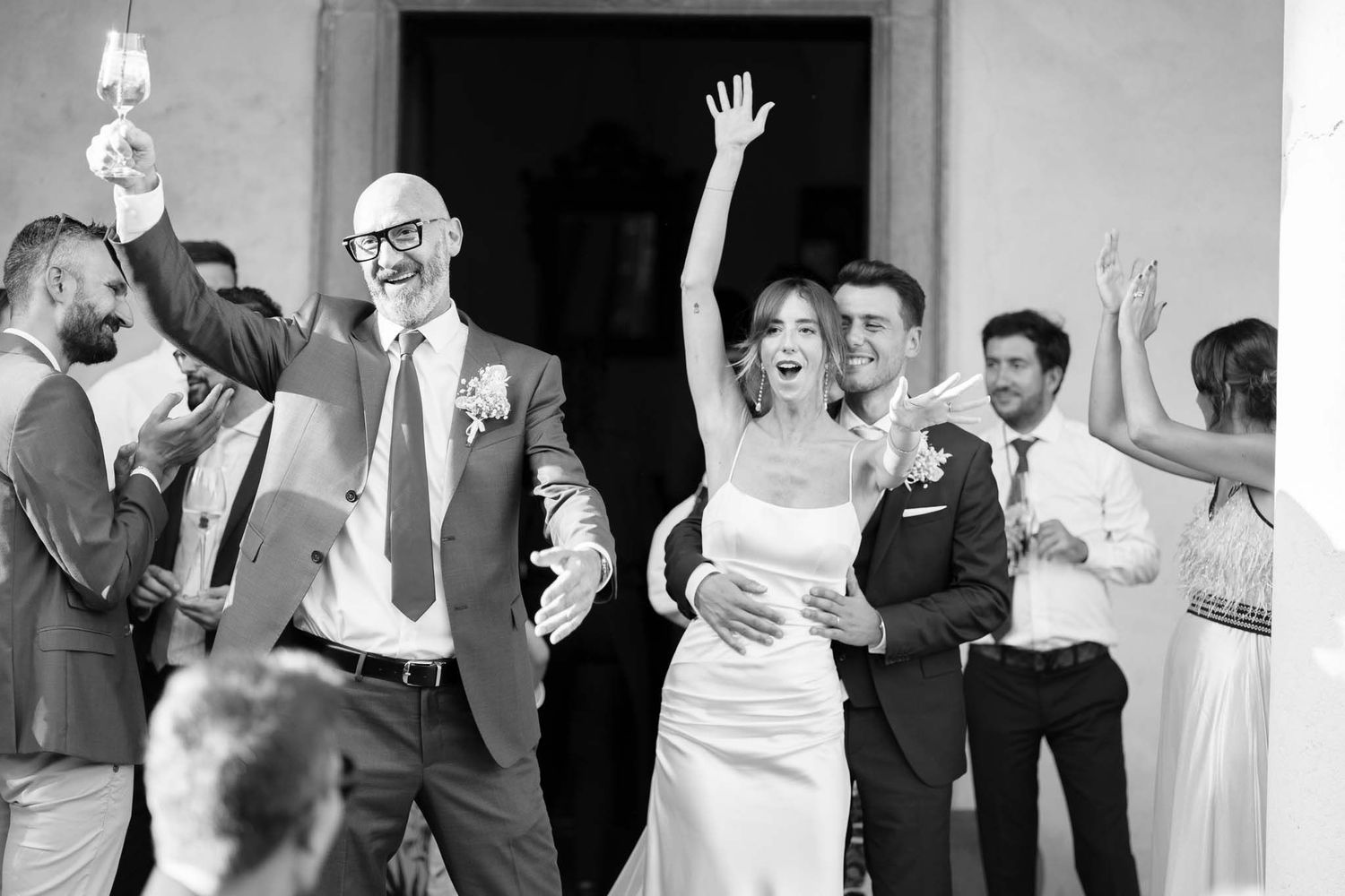 Wedding celebration in black and white with guests dancing and celebrating.