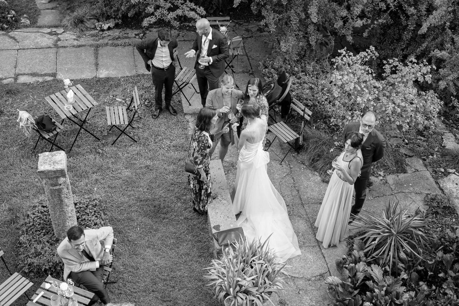 Aerial view of wedding guests gathered in a garden setting.