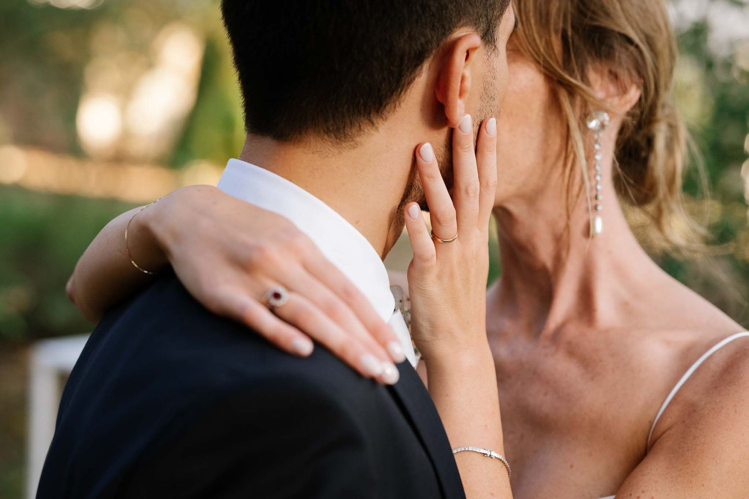 Close-up of tender wedding moment showing delicate hand placement and jewelry details.