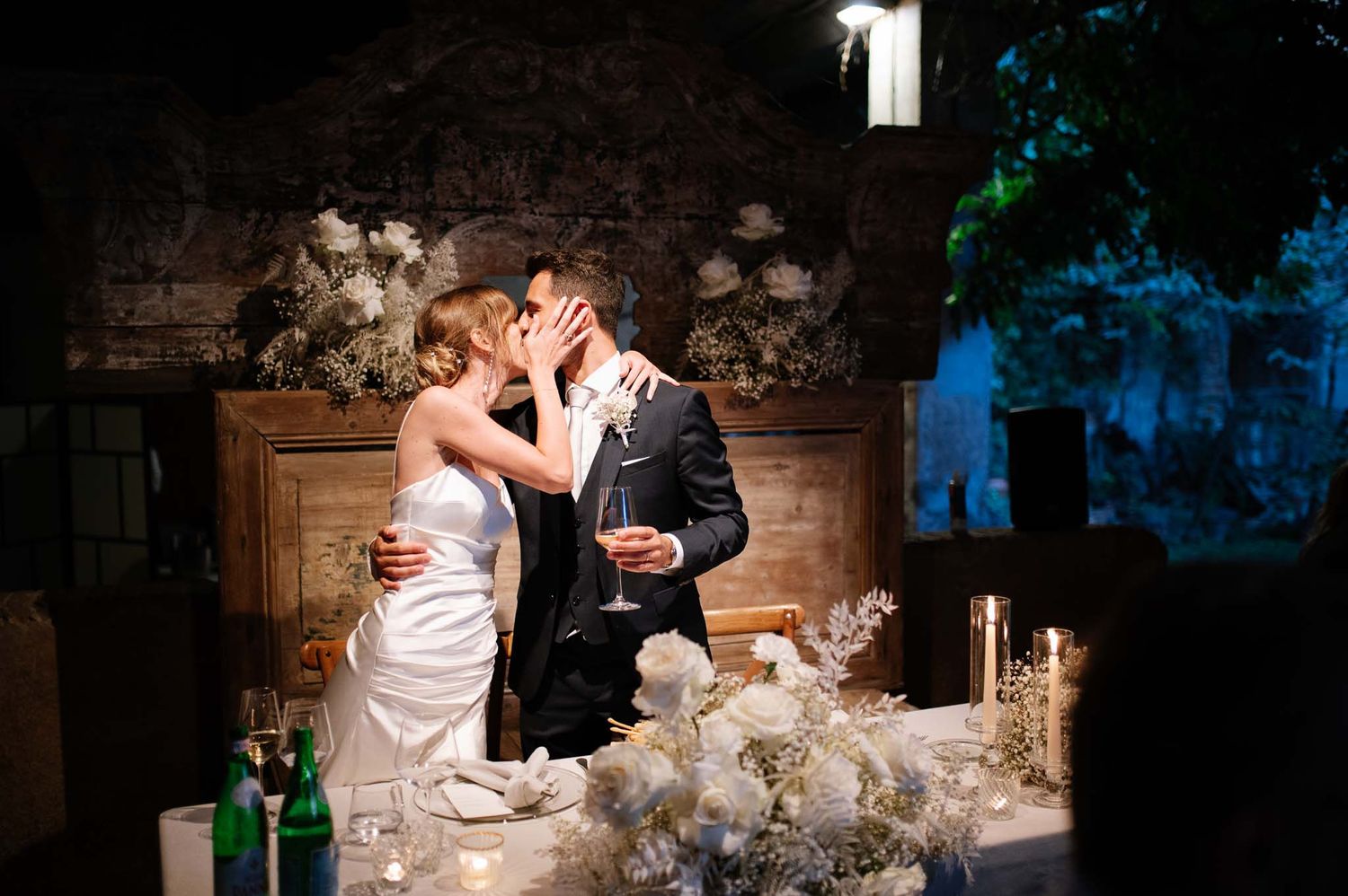 Romantic candlelit moment between newlyweds at their rustic reception.