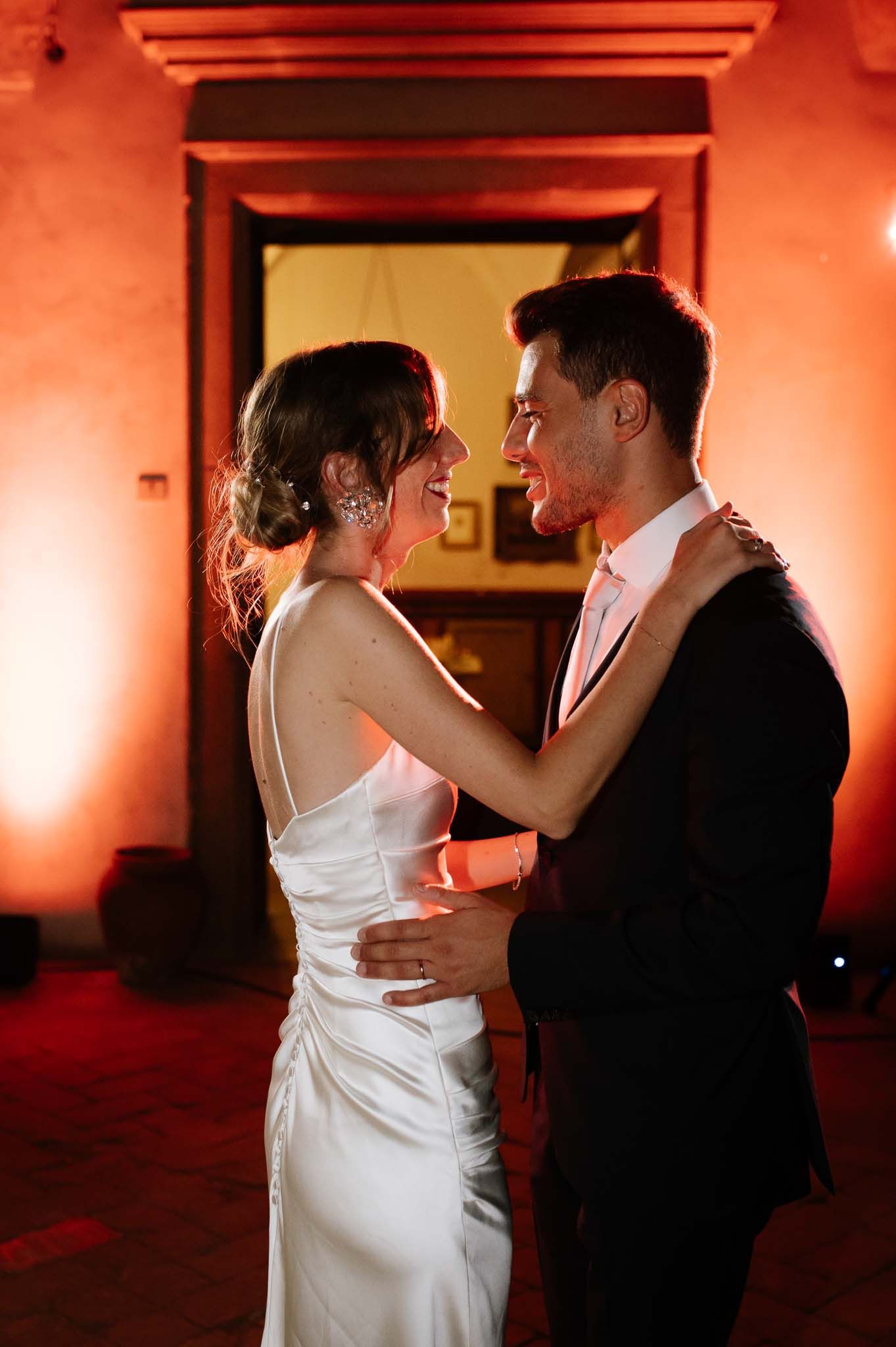 A romantic dance scene with warm lighting and elegant formal attire.