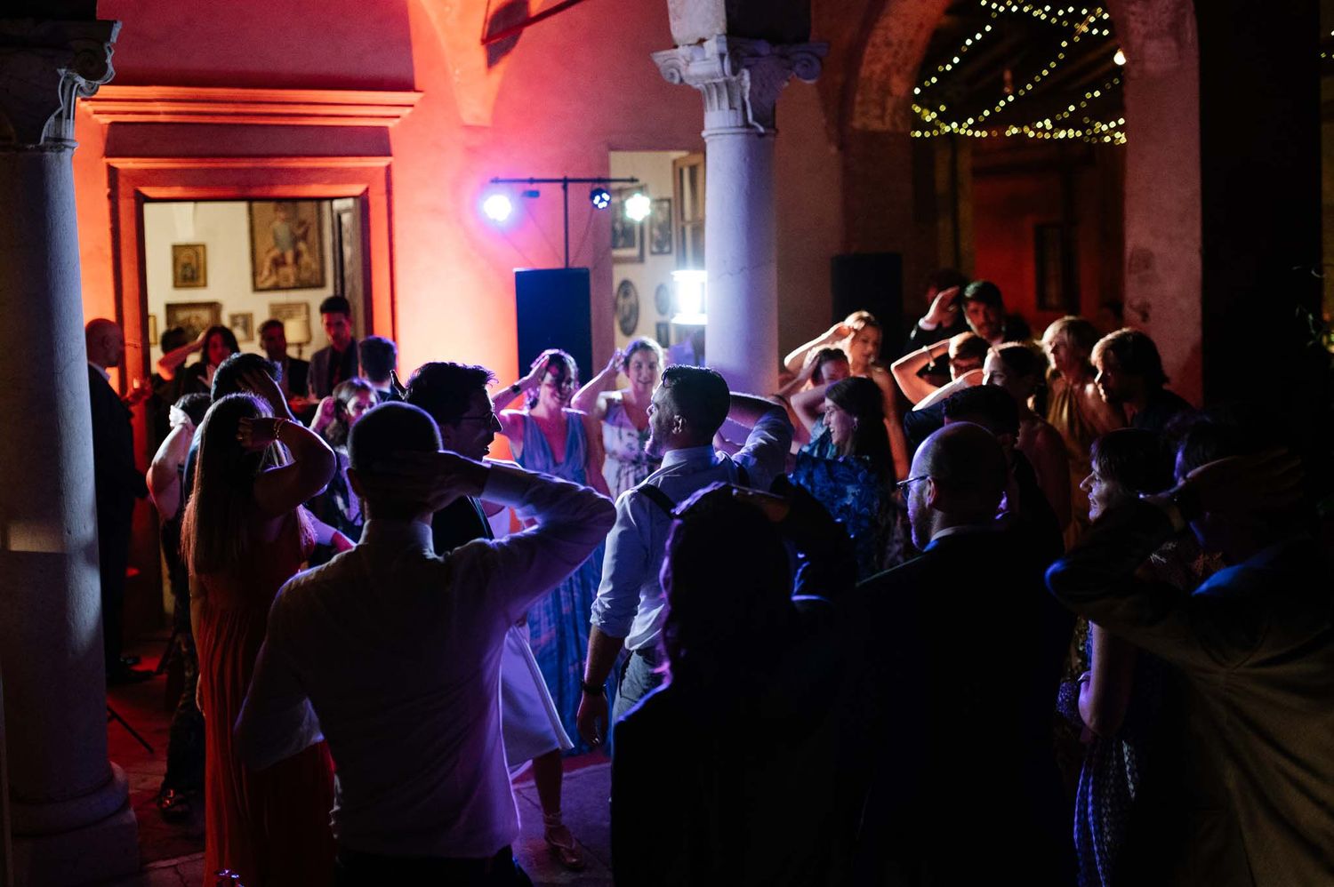 A lively dance floor scene with guests moving under atmospheric blue lighting at an indoor venue.