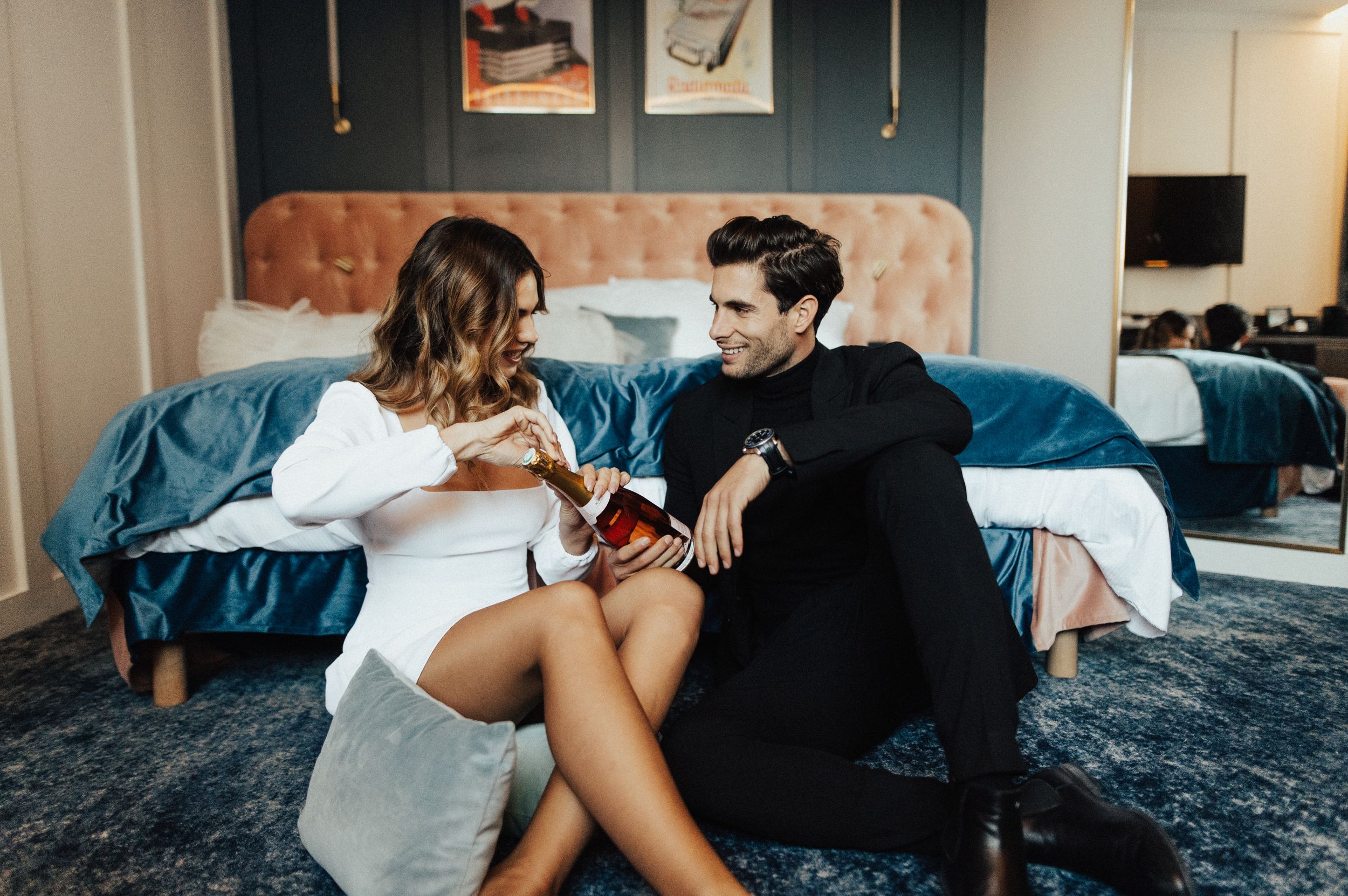 Romantic indoor photography session with couple on blue bedding.