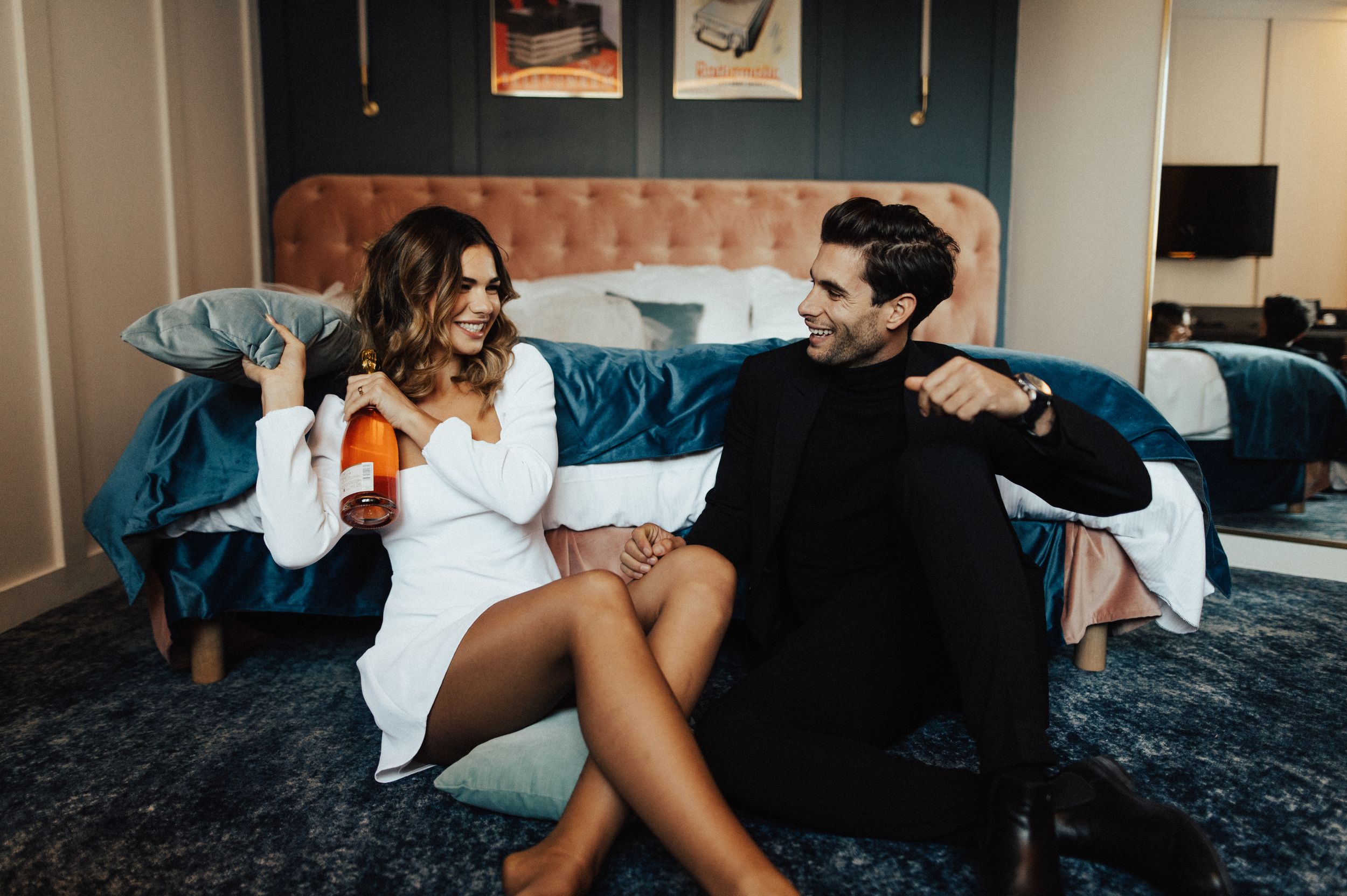 Intimate indoor couple photoshoot with moody lighting and casual setting.