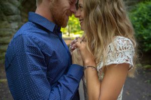 An intimate moment between a couple holding hands and sharing a close embrace.