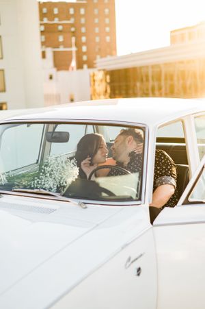 Romantic moment captured in vintage white car during golden hour sunset in Fairfield, CT.