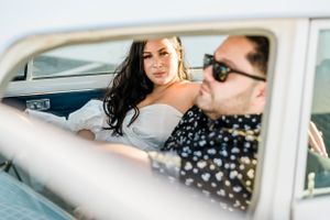 Stylish couple sharing intimate moment inside vintage car.