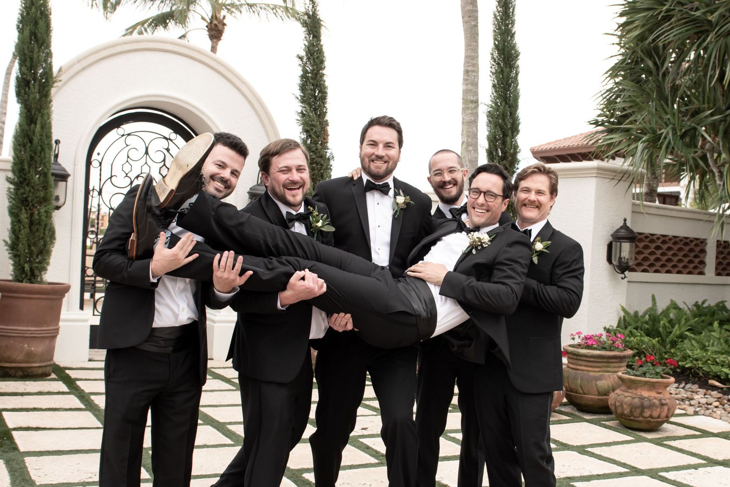 groom and groomsmen having fun on wedding day beautiful outdoor setting