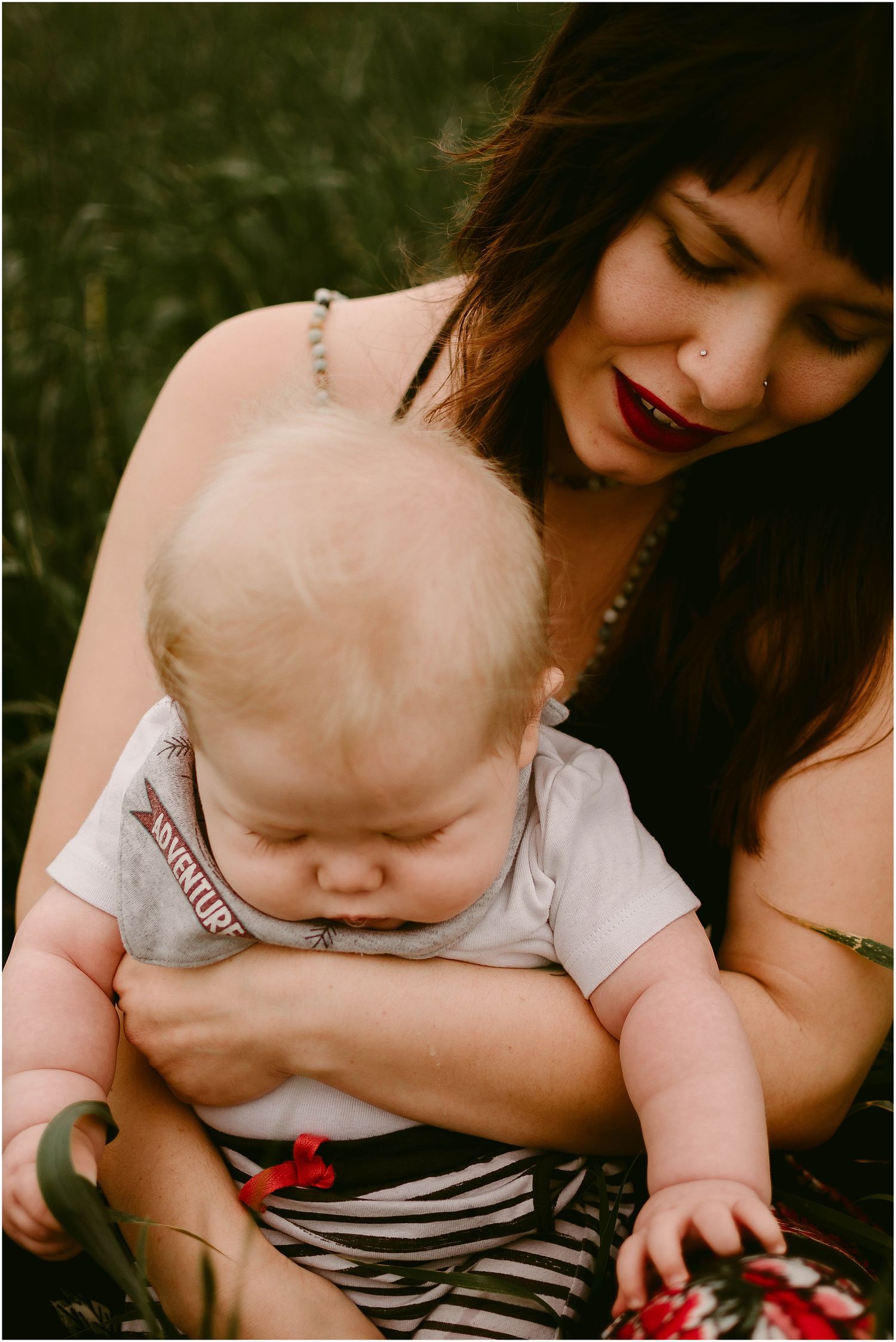 Close bonding moment in a grassy field wearing casual summer attire.