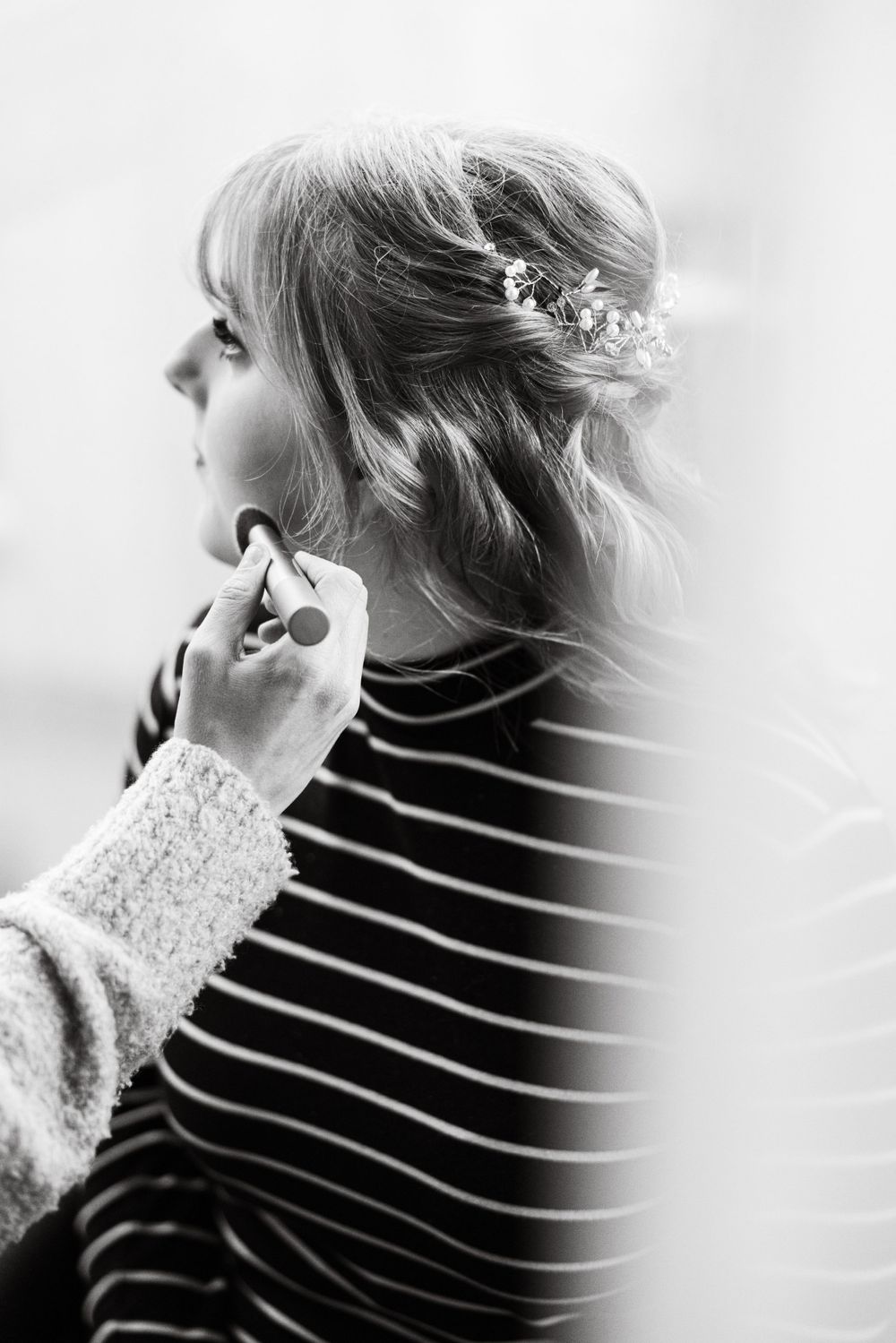Black and white profile portrait showing delicate hair accessories and striped clothing.