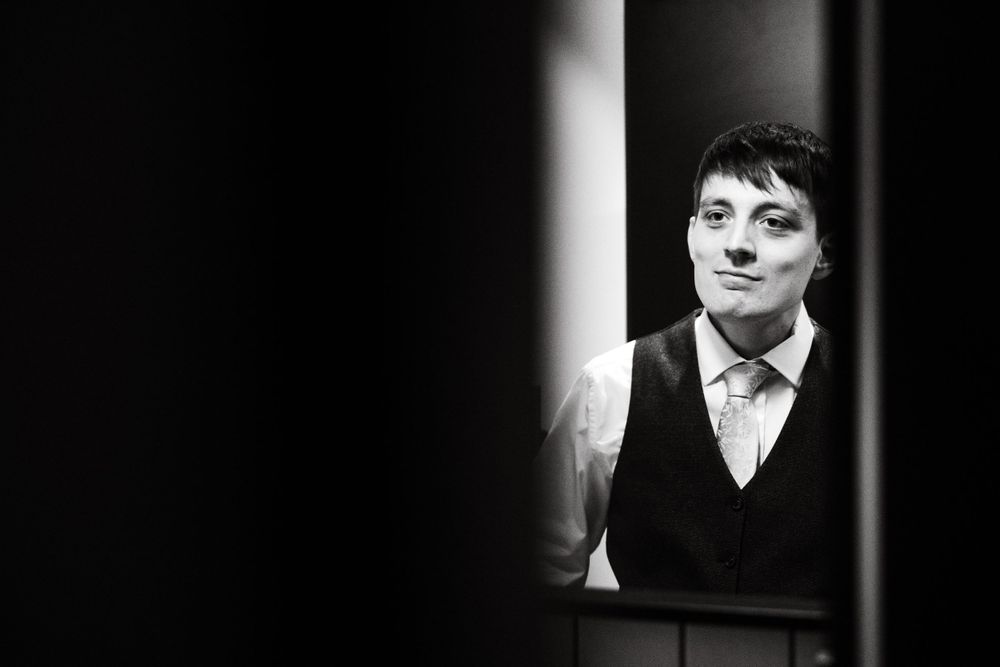 Black and white portrait with dramatic lighting and architectural framing.