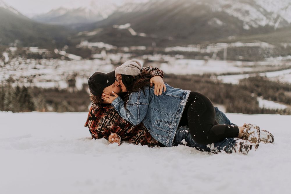 A playful winter photo session in deep snow with mountain views.