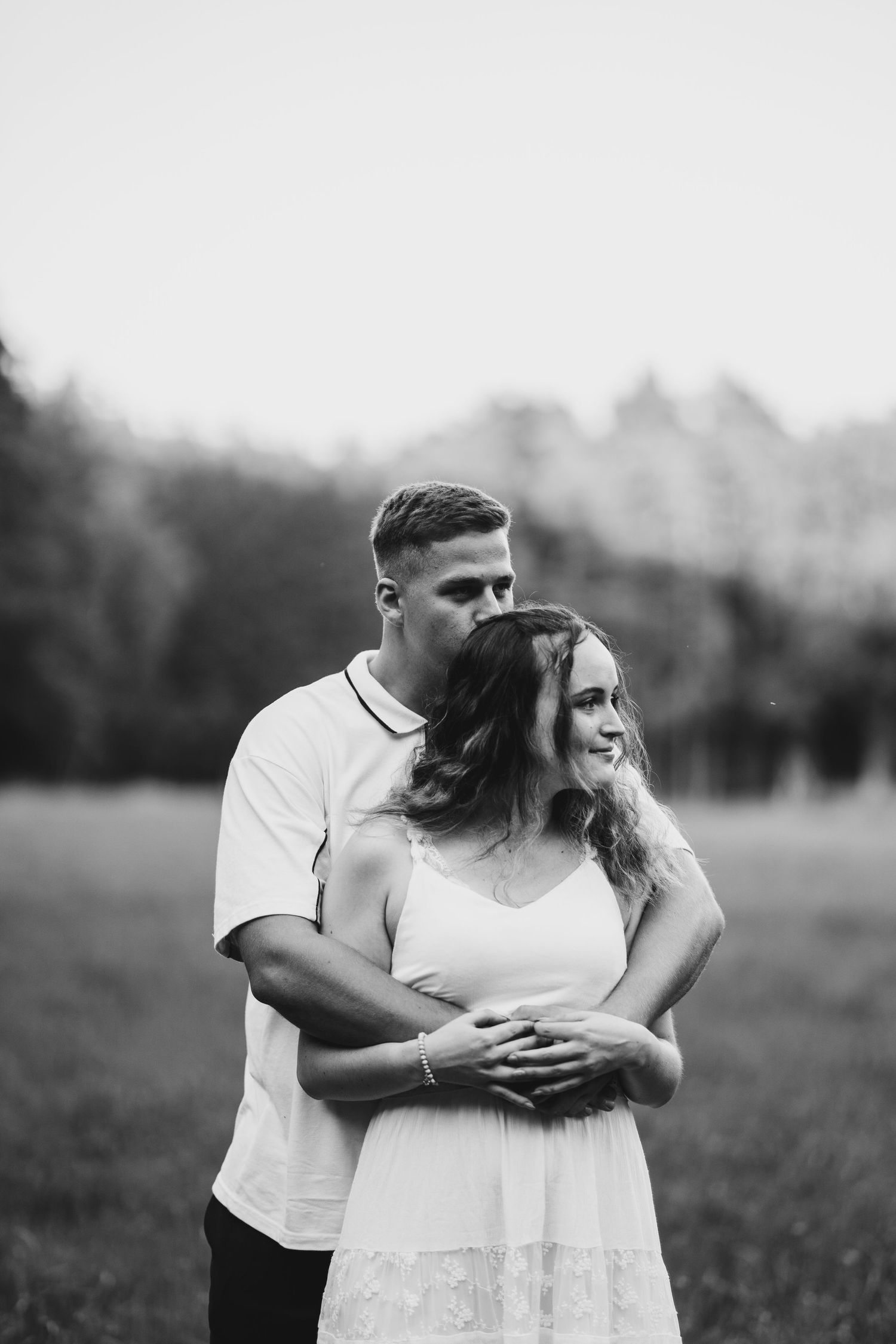 Intimate black and white couple's photoshoot in an outdoor field.