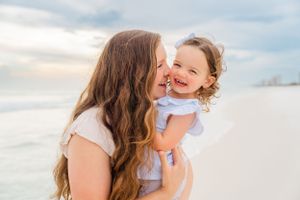 Sweet moment shared between parent and child on sunny beach.