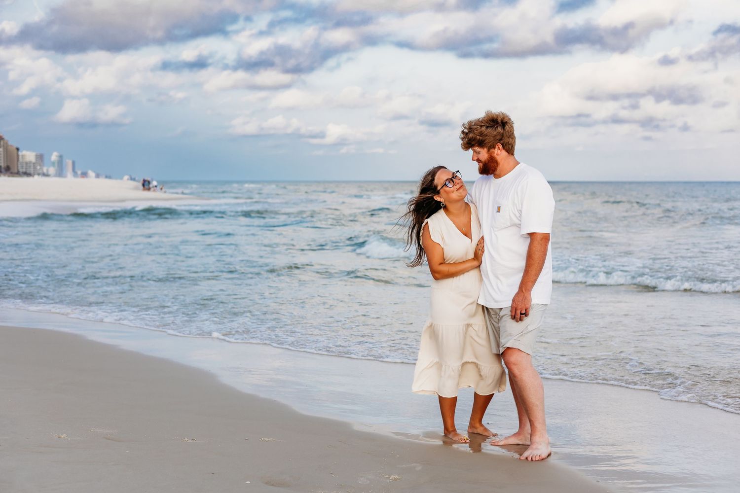 A series of beach photos showing a couple walking and playing in the sand near the ocean.
