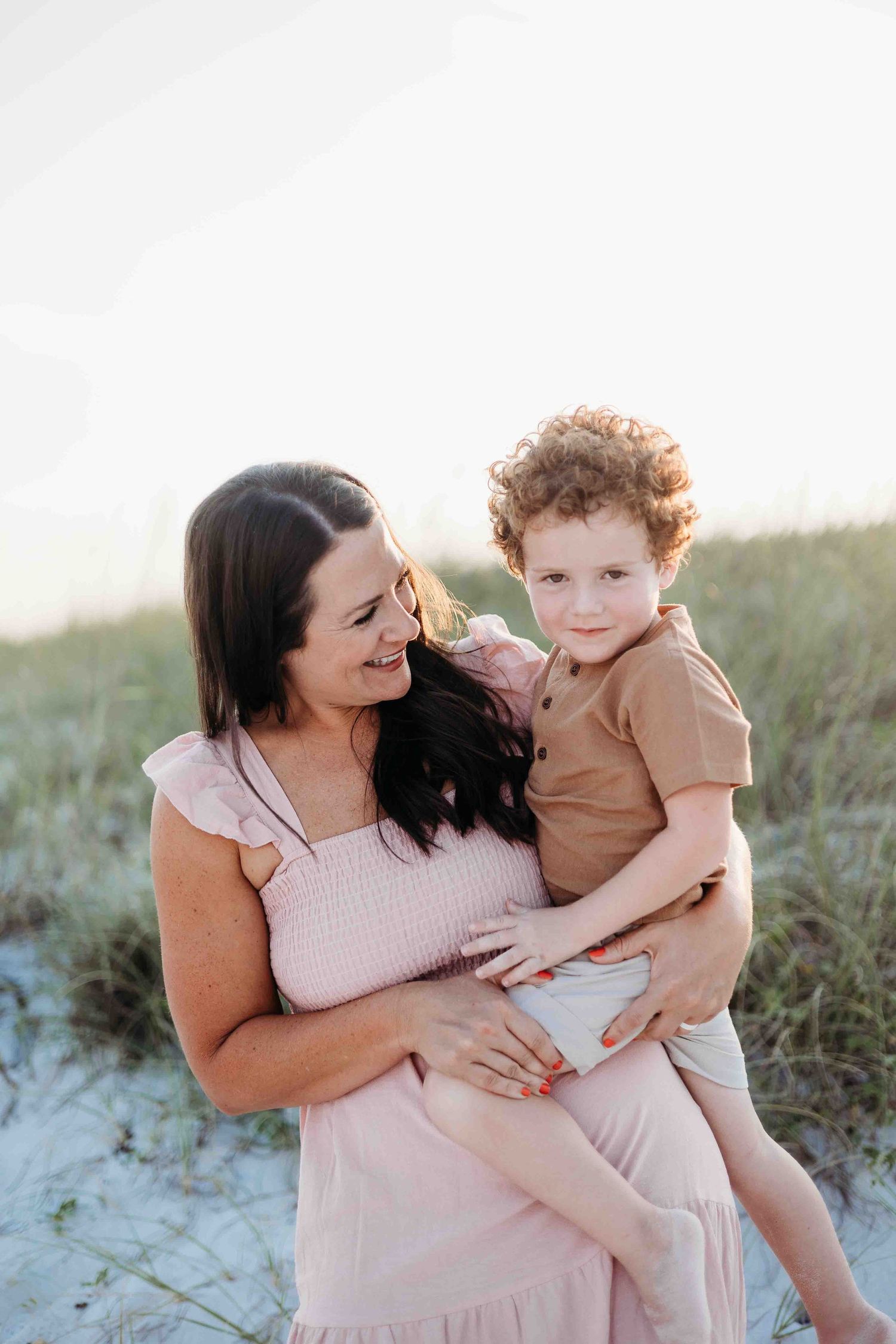 Loving family embrace captured during sunset at a scenic beach location.