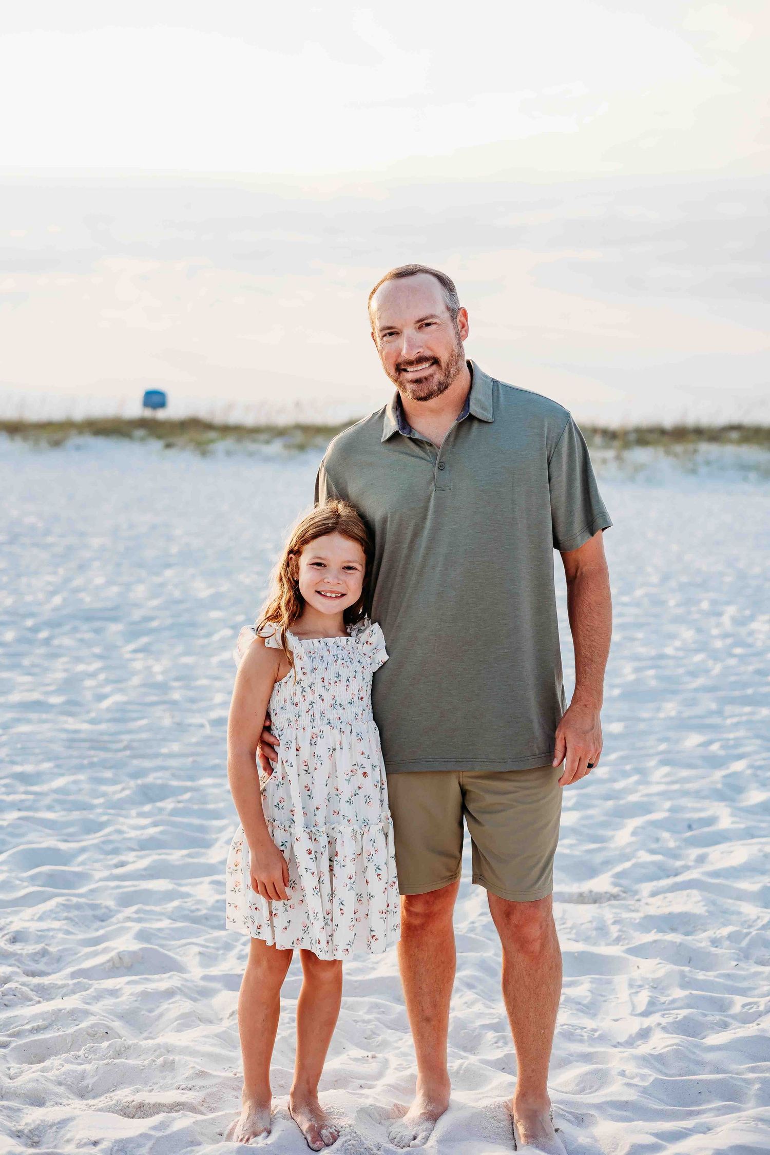 Family portrait on pristine white sand beach during sunset.