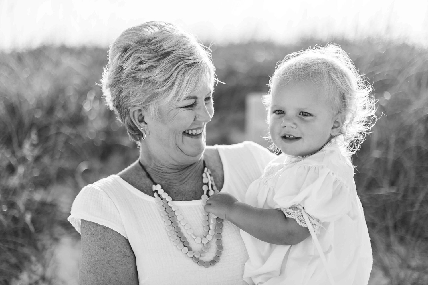 Black and white candid beach portraits showing joyful family moments.