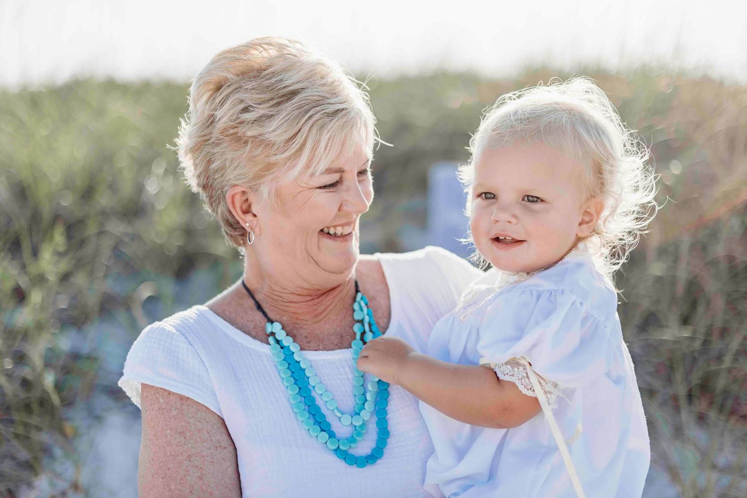 Candid beach photos capturing sweet interactions between family members in natural light.