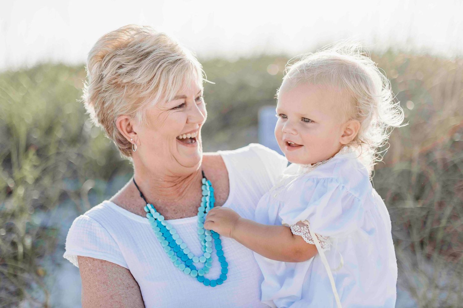 Candid moments of family laughter and joy during a beach photoshoot.