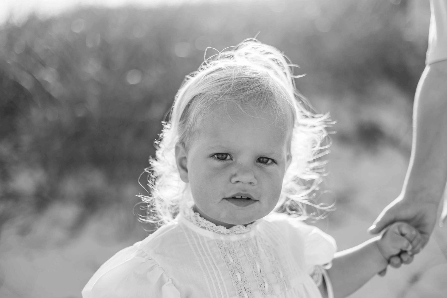 Black and white candid portraits of children on a sunny beach.