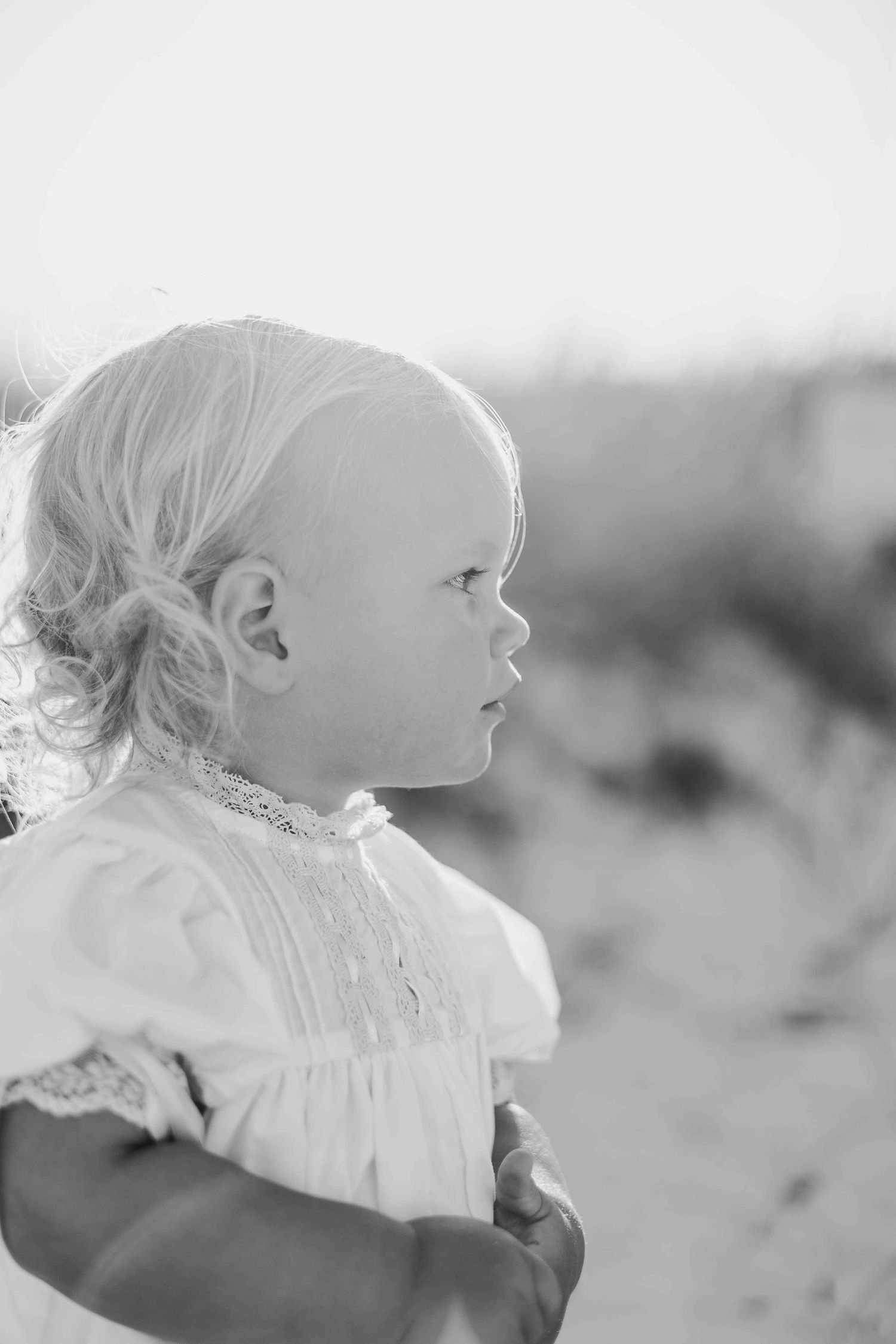 Side profile silhouettes of a small child in a white dress against a light background.