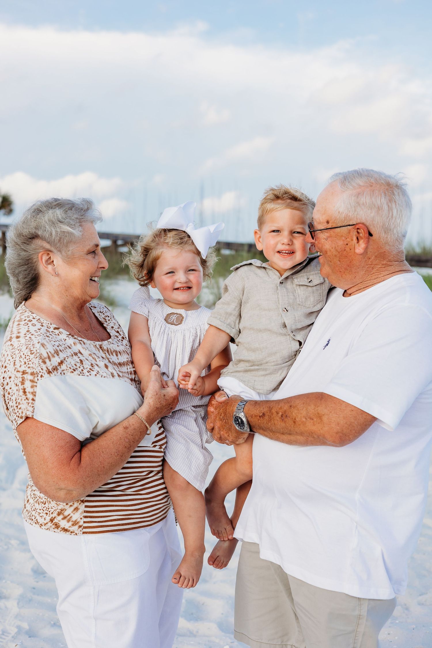 Family shares joyful moments together on a bright sunny beach with white sand.