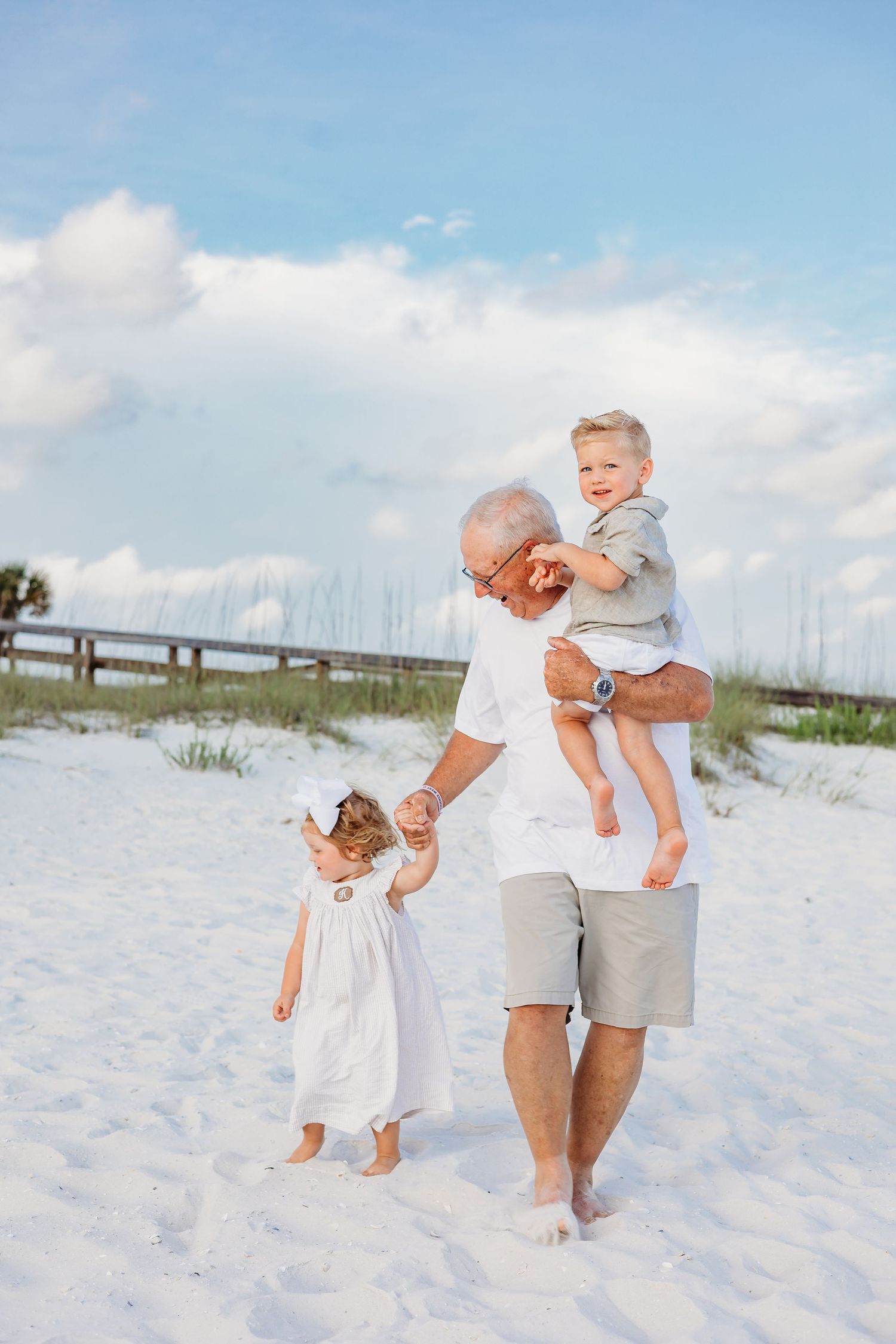 Active family members playing and running together on pristine beach sand.