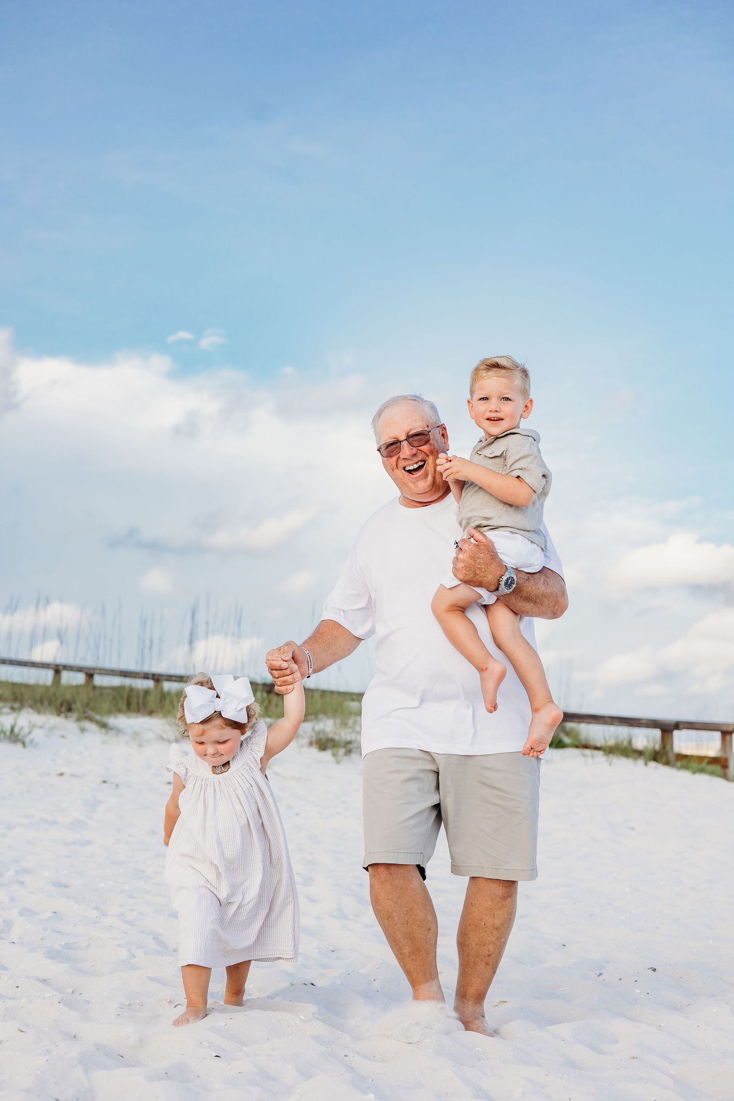 Family members playing and laughing together on pristine white sand beach.