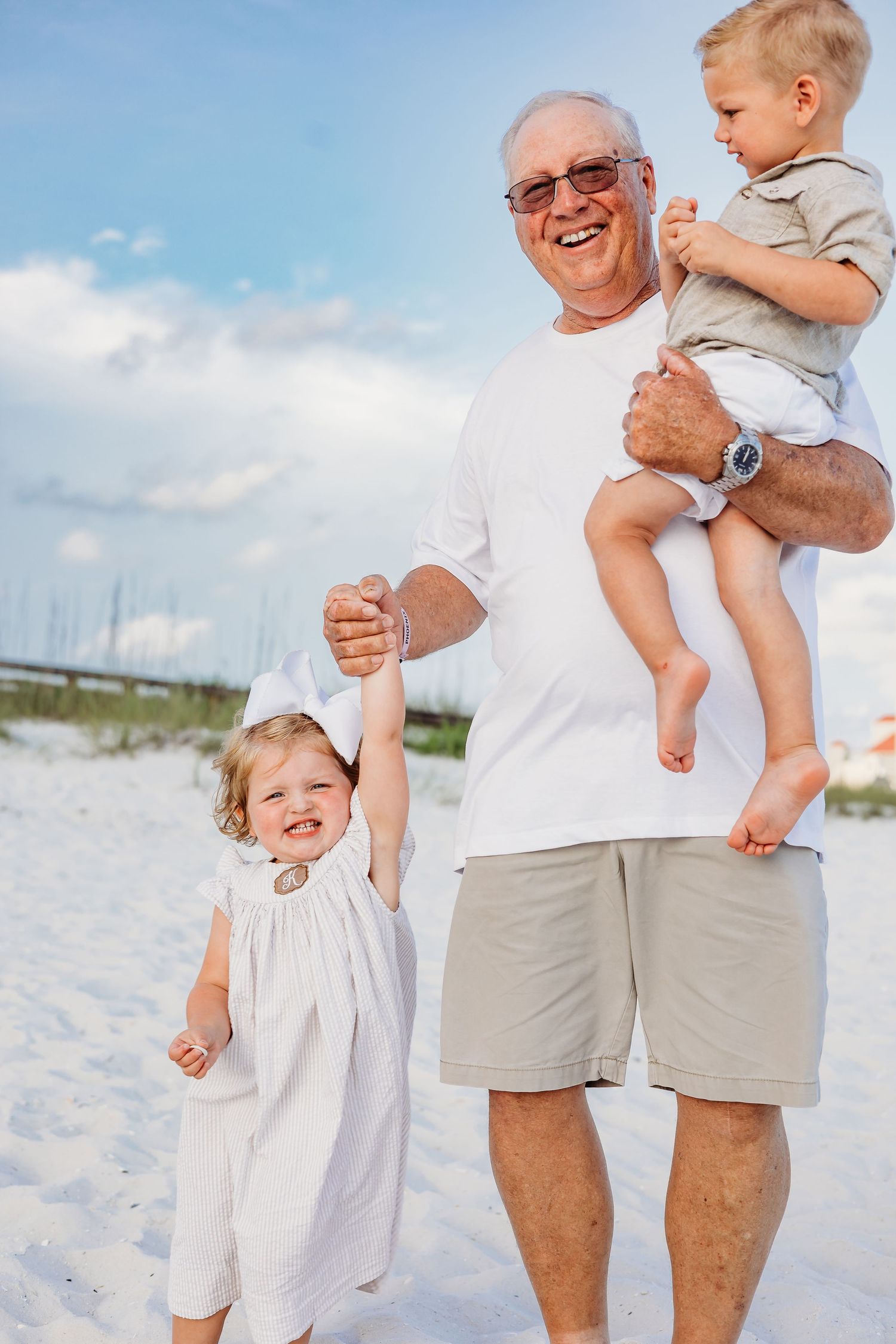Candid beach portraits showing playful interactions between generations on white sand.