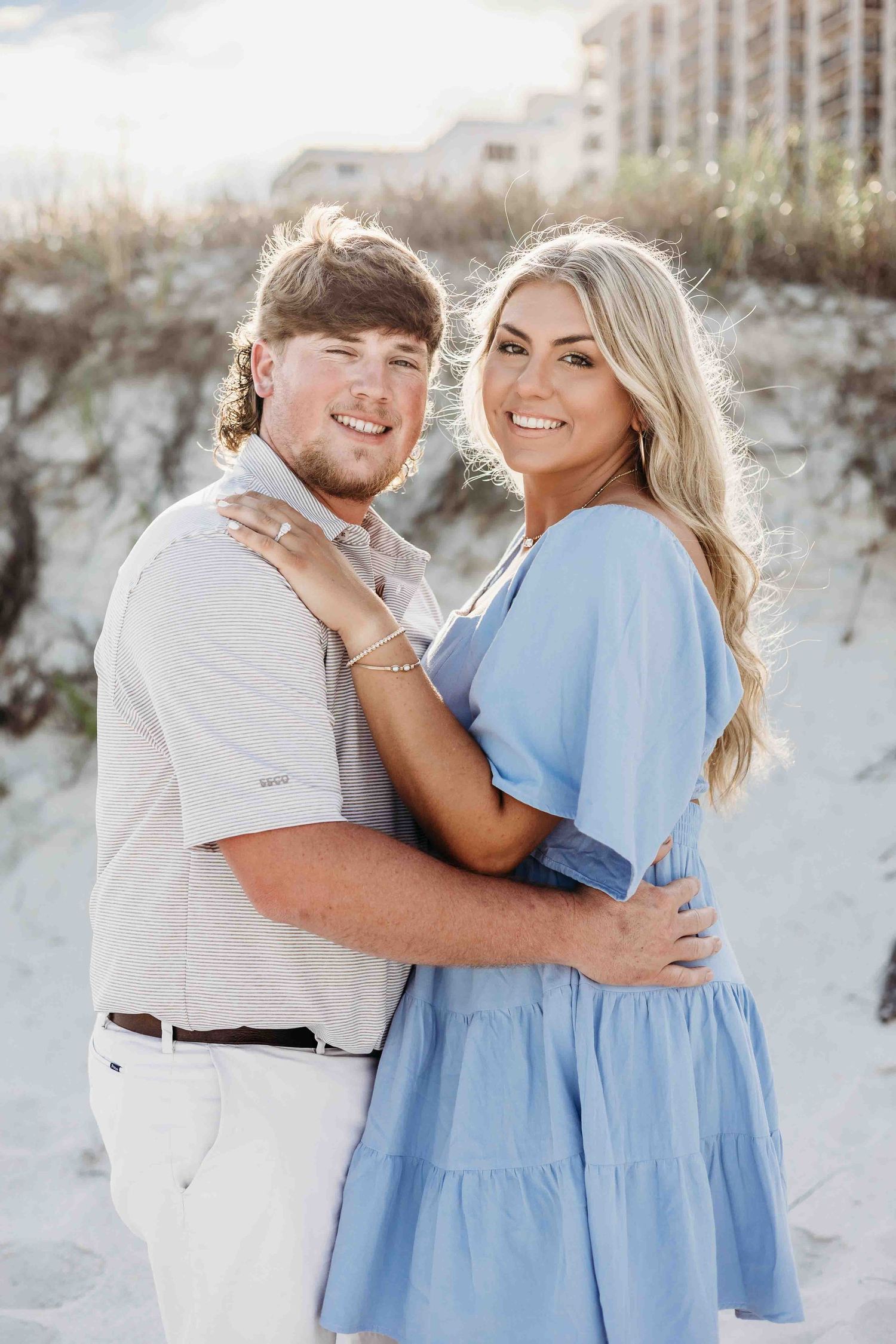 Two people share affectionate moments during their beach photography session.