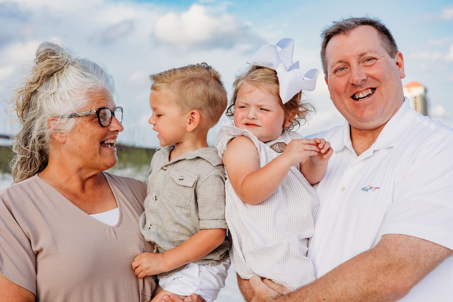 Candid moments of family bonding captured during a sunny beach photoshoot.