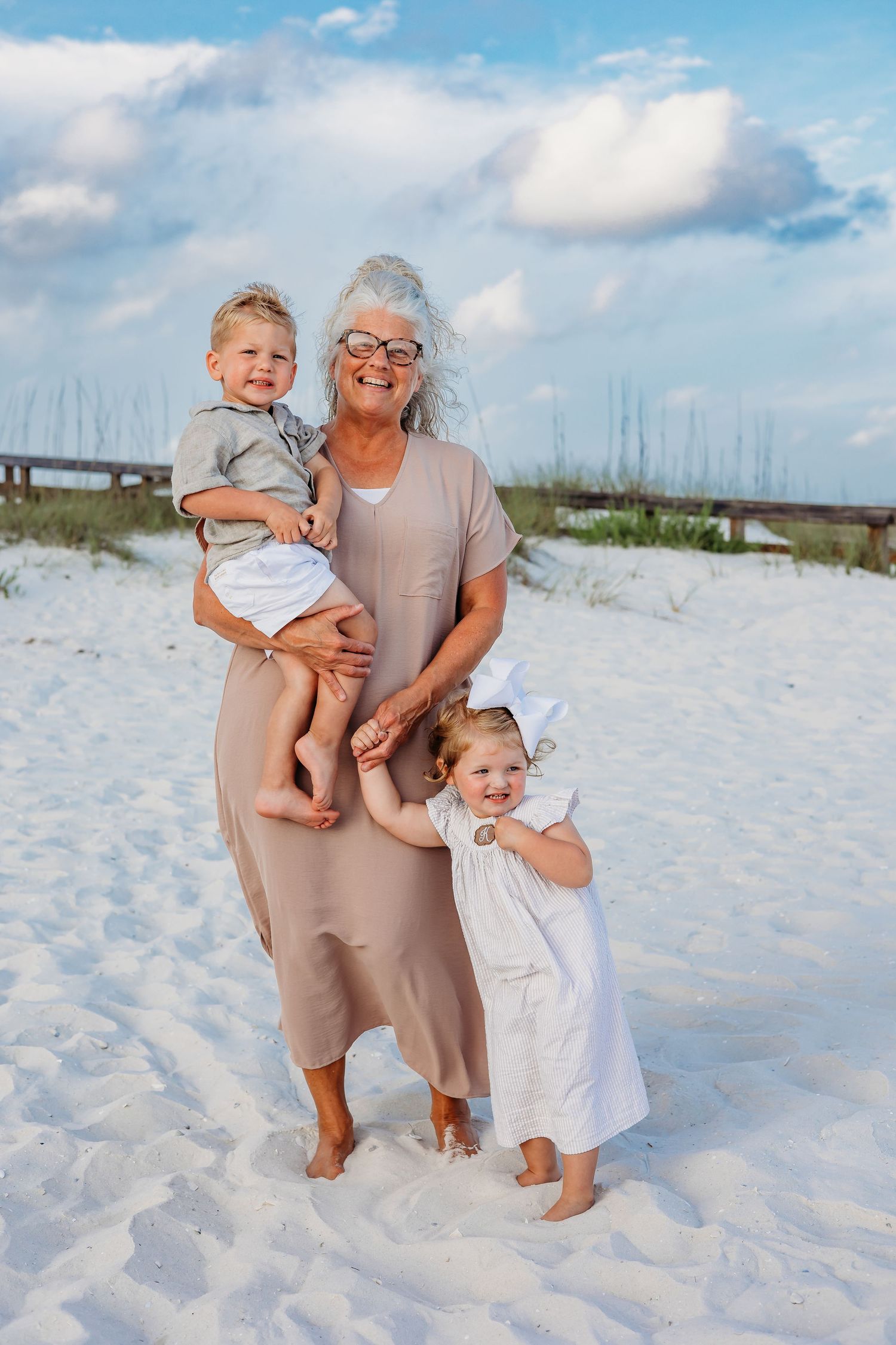 Sweet family moments captured during a casual beach photo session with sand dunes.