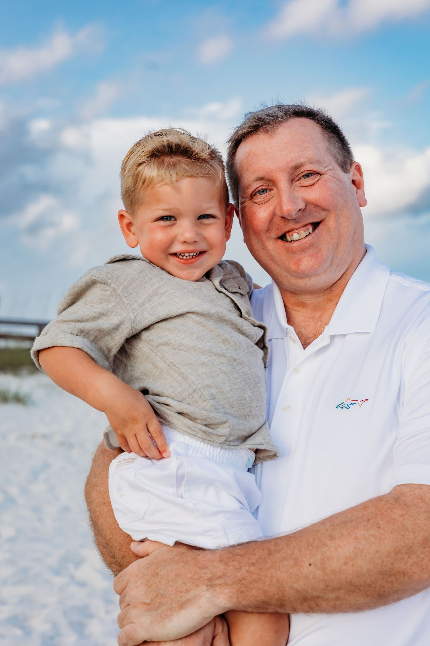 Joyful expressions shared between family members during a beach portrait session.