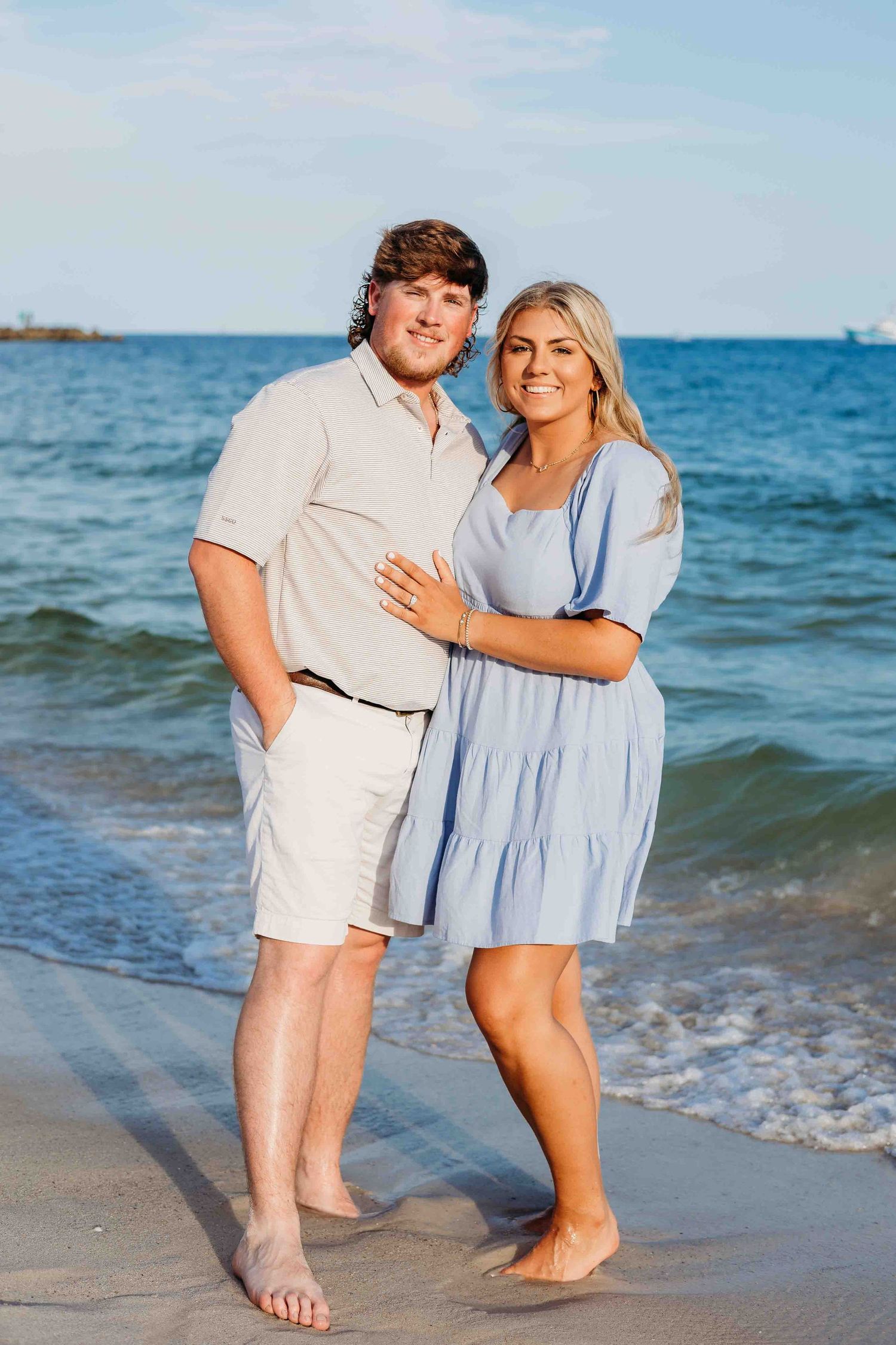Couple enjoying a tender moment together while standing in the ocean waves at the beach.