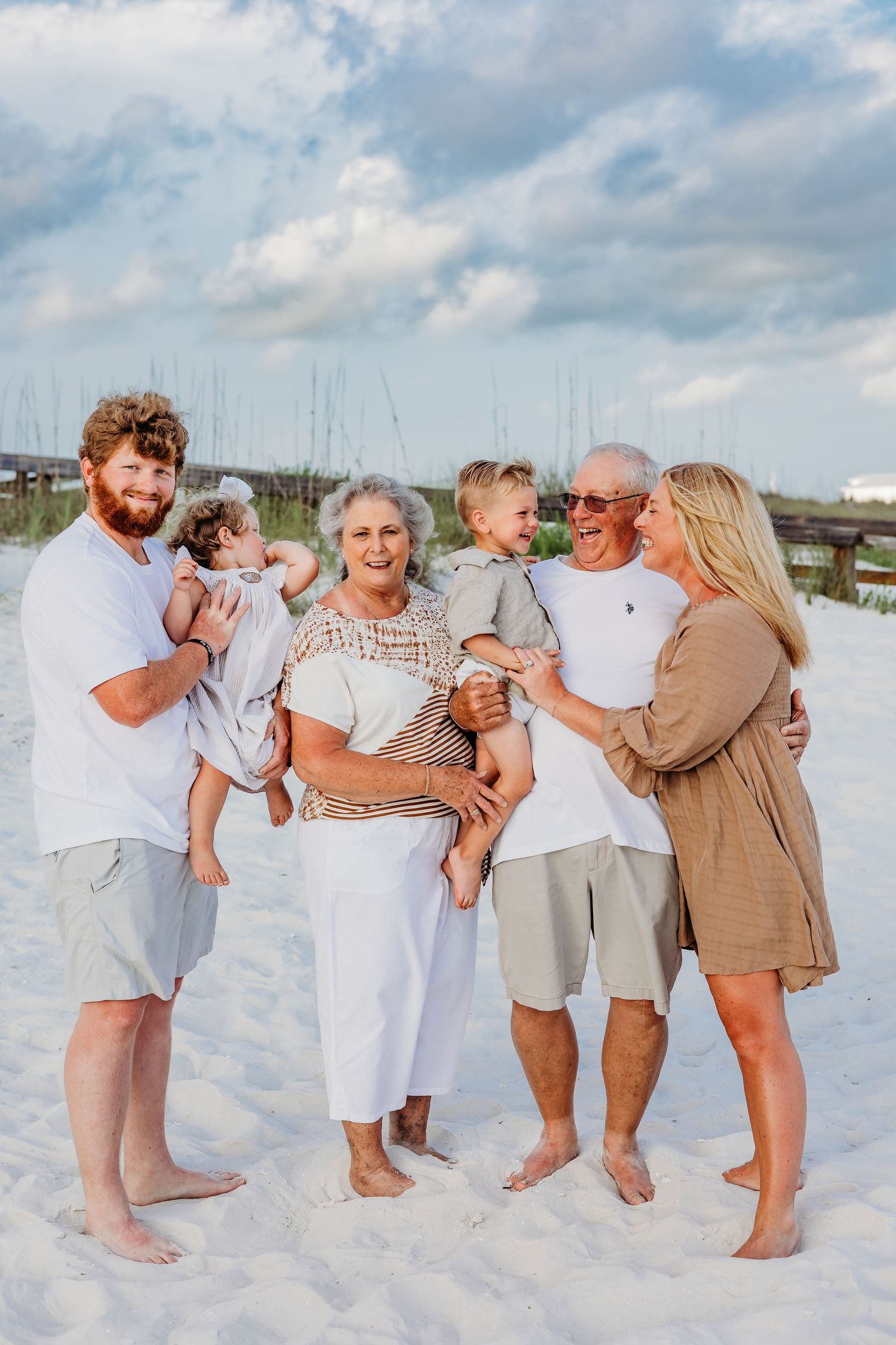 Multi-generational family sharing candid moments together on a sunny beach.