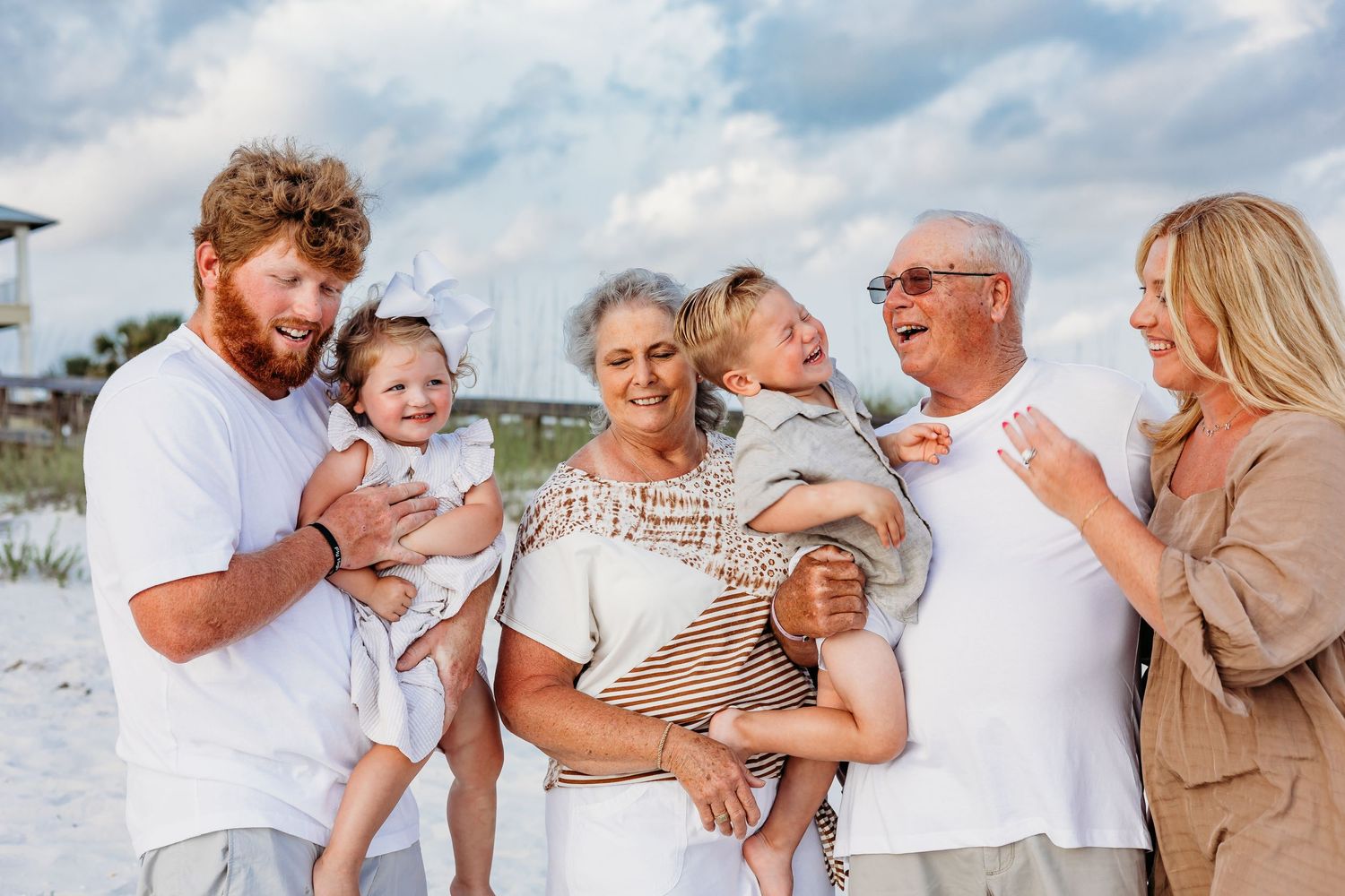 Candid family beach photo with everyone laughing and interacting naturally.
