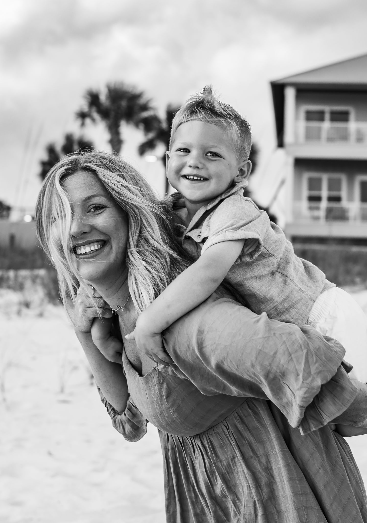 Black and white photos capture playful family moments on a sunny beach.